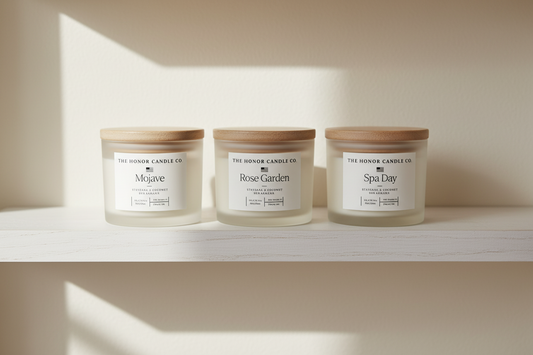 Three Honor Candle Co. hand-poured beeswax candles displayed on an oak shelf with warm side lighting