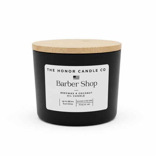 Black candle with wooden lid from The Honor Candle Co, featuring a white label with the scent name.