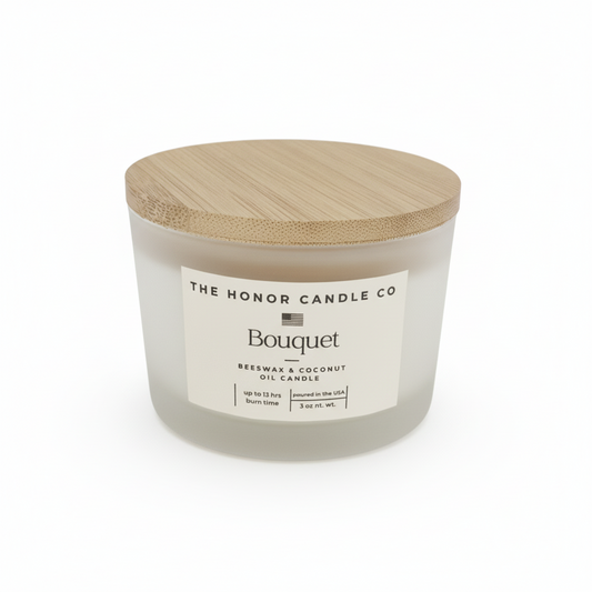 White bouquet candle by The Honor Candle Co with a wooden lid on a white background.